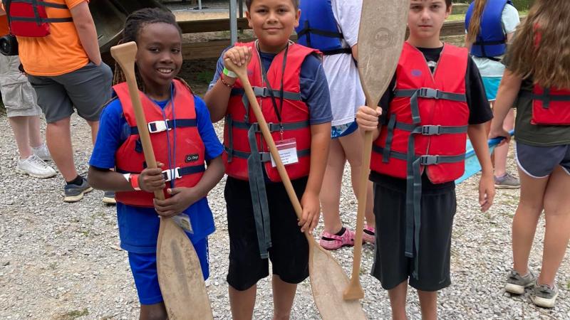 Three children holding boat oars
